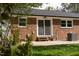 Charming brick home featuring a cozy backyard patio, complemented by lush greenery and mature trees at 3910 Hillgrand Dr, Durham, NC 27705