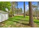 Spacious backyard with mature trees, storage shed, and brick home in the distance at 3910 Hillgrand Dr, Durham, NC 27705