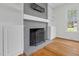 Cozy fireplace featuring gray brick, built-in shelving, and stylish hardwood floors at 3910 Hillgrand Dr, Durham, NC 27705