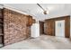 Spacious garage featuring brick accents, concrete floors, and a convenient refrigerator at 3910 Hillgrand Dr, Durham, NC 27705
