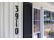 Close-up of the house number 3910 on the exterior wall next to a window with black shutters at 3910 Hillgrand Dr, Durham, NC 27705