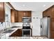 Kitchen with stainless steel appliances, granite countertops, and wooden cabinetry at 3910 Hillgrand Dr, Durham, NC 27705