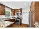 Well-lit kitchen featuring wooden cabinets, stainless steel appliances, and granite countertops at 3910 Hillgrand Dr, Durham, NC 27705