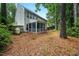 A backyard view featuring a screened-in porch, propane tank and view of the treelined property at 4070 Landover Ln, Raleigh, NC 27616