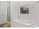 Bright bathroom with a soaking tub, a large window, and a separate shower with a glass door at 4070 Landover Ln, Raleigh, NC 27616