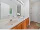 Bathroom featuring double sinks with a wooden vanity, a large mirror, and ample lighting at 4070 Landover Ln, Raleigh, NC 27616