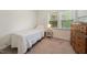 Charming bedroom with a large window, carpet floors, and a classic wood dresser at 4070 Landover Ln, Raleigh, NC 27616