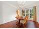 Elegant dining room with chandelier, hardwood floors, and a view to the backyard through windows at 4070 Landover Ln, Raleigh, NC 27616