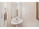 Bright powder room featuring a pedestal sink, neutral walls, and a framed mirror at 4070 Landover Ln, Raleigh, NC 27616