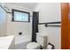 Bathroom with subway tile, shower-tub combination, dark trim, and window for natural light at 412 Suburb St, Rocky Mount, NC 27801