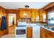 Well-lit kitchen featuring wood cabinetry, white appliances, and tile flooring at 412 Suburb St, Rocky Mount, NC 27801