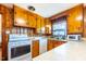 Kitchen featuring classic wood cabinetry, white appliances, and quartz countertops at 412 Suburb St, Rocky Mount, NC 27801