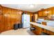 Bright kitchen featuring a breakfast bar, wood paneled walls, and stainless steel appliances at 412 Suburb St, Rocky Mount, NC 27801