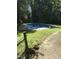 View of an in-ground pool surrounded by a stone patio and lush greenery, perfect for outdoor relaxation at 4324 Old Lewis Farm Rd, Raleigh, NC 27604