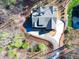 An aerial view of a home showcasing its unique roofline and freshly paved driveway nestled in a serene, wooded lot at 4721 Cypress Ford Dr, Fuquay Varina, NC 27526