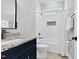Modern bathroom showcasing granite countertop, navy cabinets, and a tiled shower-tub combination at 4721 Cypress Ford Dr, Fuquay Varina, NC 27526