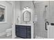 This bathroom features a modern vanity with granite countertop and a glass-enclosed shower with grey tiling at 4721 Cypress Ford Dr, Fuquay Varina, NC 27526