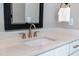 Bathroom sink and dark framed mirror with brass fixtures and white quartz countertop at 4721 Cypress Ford Dr, Fuquay Varina, NC 27526