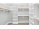Large walk-in closet with built-in shelving and wooden closet rods, carpeted floor at 4721 Cypress Ford Dr, Fuquay Varina, NC 27526