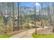 View of gray homes from the driveway, surrounded by a wooded area and white fences, showcasing the neighborhood setting at 4721 Cypress Ford Dr, Fuquay Varina, NC 27526