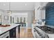 Open-concept kitchen with island seating and views into the dining and living spaces at 4721 Cypress Ford Dr, Fuquay Varina, NC 27526