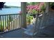 Relaxing porch view with white rocking chairs and a glimpse of the lake and lush landscaping beyond at 4721 Cypress Ford Dr, Fuquay Varina, NC 27526