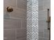 Close up of shower featuring stone floors, gray tiled walls and bronze fixtures at 4721 Cypress Ford Dr, Fuquay Varina, NC 27526