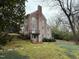 Exterior view of a brick house featuring a chimney, balcony, and backyard at 501 North St, Chapel Hill, NC 27514