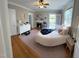 Cozy bedroom featuring hardwood floors, a ceiling fan, large bed and a decorative fireplace at 501 North St, Chapel Hill, NC 27514