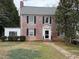 Charming two-story brick home with black shutters, a gray roof, and landscaped front yard, offering classic curb appeal at 501 North St, Chapel Hill, NC 27514