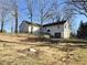 Spacious backyard with mature trees and a two-story home providing ample outdoor space and privacy at 512 Monroe Holt Rd, Graham, NC 27253