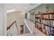 Upper hallway with skylights, railing, and bookshelves with an open view down to the lower level at 515 Swim & Croquet, Pittsboro, NC 27312
