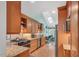 Galley kitchen featuring wood cabinets, granite countertops, stainless steel appliances, and a skylight at 515 Swim & Croquet, Pittsboro, NC 27312