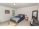 Bright bedroom with a bed, geometric carpet, large mirror and a keyboard on the carpet at 609 Rawls Dr, Raleigh, NC 27610