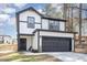 Two story home with black framed windows, a two-car garage, and a grassy front yard at 609 Rawls Dr, Raleigh, NC 27610