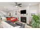 Open concept living room with a cozy fireplace, ceiling fan, and an abundance of natural light at 609 Rawls Dr, Raleigh, NC 27610