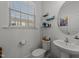 Bright powder room featuring pedestal sink, decorative mirror, and a sunny window at 6205 Taylor Rd, Wendell, NC 27591