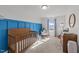 Bright Bedroom featuring a crib, rocker, and blue accent wall with carpeting at 6205 Taylor Rd, Wendell, NC 27591