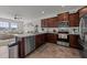 Well-lit kitchen with stainless steel appliances, granite countertops, and stylish dark wood cabinetry at 6205 Taylor Rd, Wendell, NC 27591
