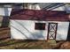 A quaint outbuilding with a red roof, a window, and an 'X' designed door adds storage and charm to the property at 6600 Coach Light Cir, Raleigh, NC 27613