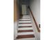 Staircase featuring natural wood railing and neutral walls at 6600 Coach Light Cir, Raleigh, NC 27613