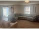 Cozy living room featuring a large sectional sofa, carpet, and natural light from sliding glass door at 700 Cider Mill Way, Zebulon, NC 27597