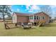 Exterior backyard view featuring a custom cooking area, stone foundation, and a wood stair case at 7155 Old Fairground Rd, Benson, NC 27504