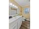 Bright bathroom featuring a large mirror and a white vanity with ample counter space and storage at 7155 Old Fairground Rd, Benson, NC 27504