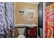 Full bathroom with colorful shower curtain and single sink vanity with mirror, showcasing functionality at 7155 Old Fairground Rd, Benson, NC 27504
