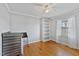 Clean, empty bedroom with natural wood floors, a built-in shelf, and a large window providing natural light at 7155 Old Fairground Rd, Benson, NC 27504