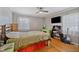 Well-lit bedroom with hardwood floors and personal touches, including a wooden bedframe, shelves, and guitar at 7155 Old Fairground Rd, Benson, NC 27504