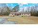 Ranch home with a large front yard, covered porch, and gravel driveway at 7155 Old Fairground Rd, Benson, NC 27504