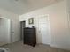 Neutral bedroom with a dark wood dresser, white doors, and neutral carpet at 829 S Franklin St, Wake Forest, NC 27587