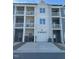 Back exterior of townhomes featuring white garages, doors, and balconies with railings at 829 S Franklin St, Wake Forest, NC 27587